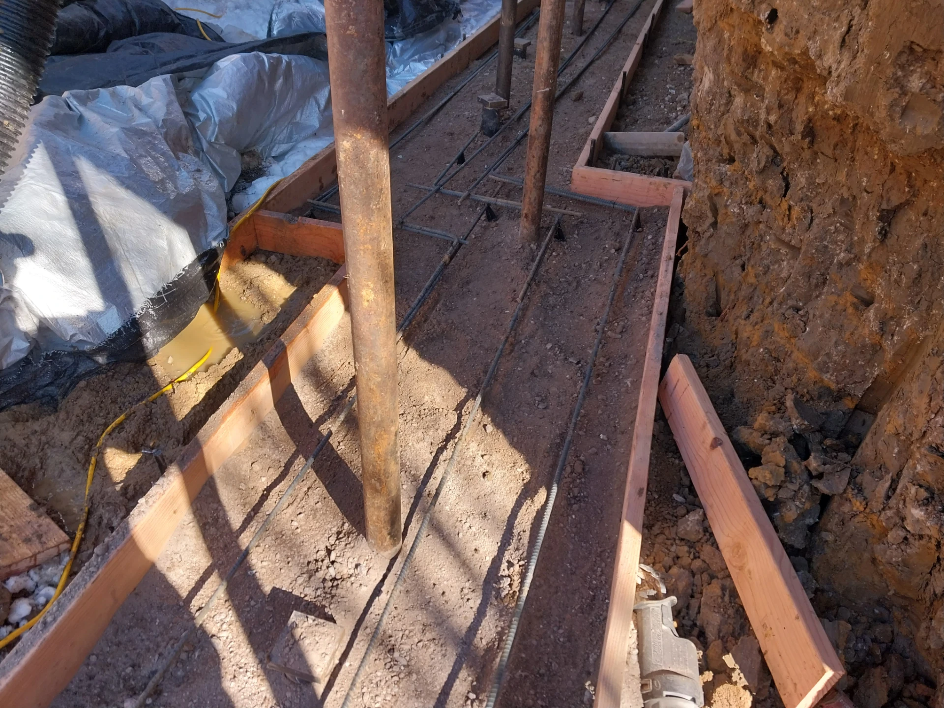 Foundation Replacement: New Footing Construction Rebar and wood forms for new foundation footing during basement conversion